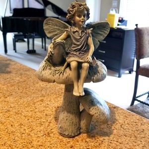 Child fairy with frog sitting on mushrooms